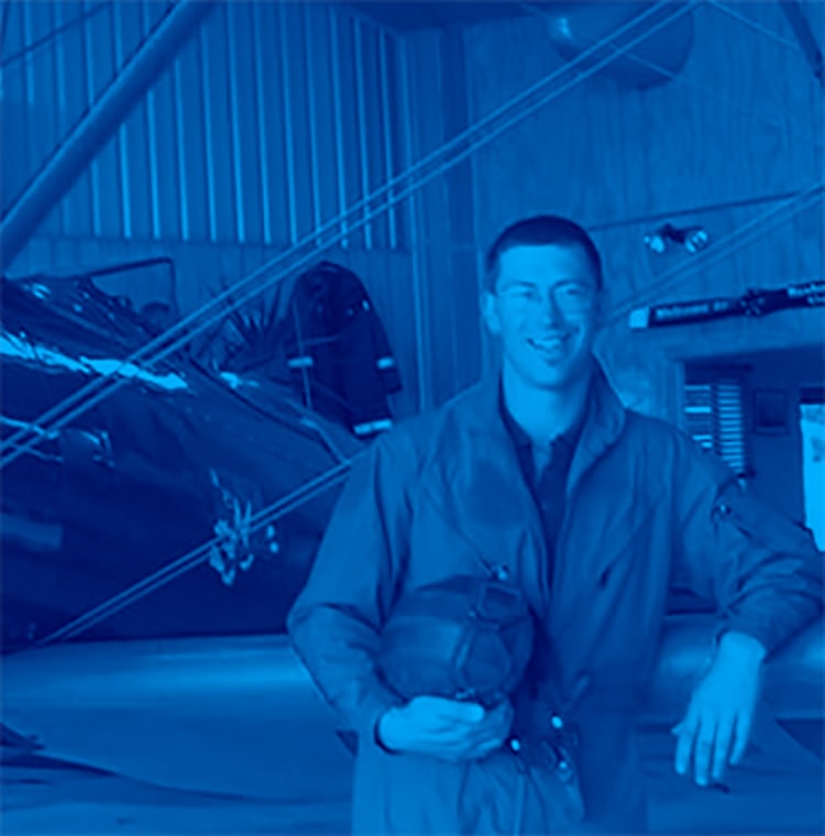 Aviation hero photo: aviator stadning in front of his plane wearing flight jacket and holdijng his helmet