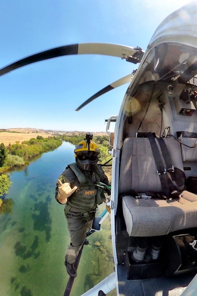 Fresno Copunty sheriff standing on helicopter skid using the boom mic